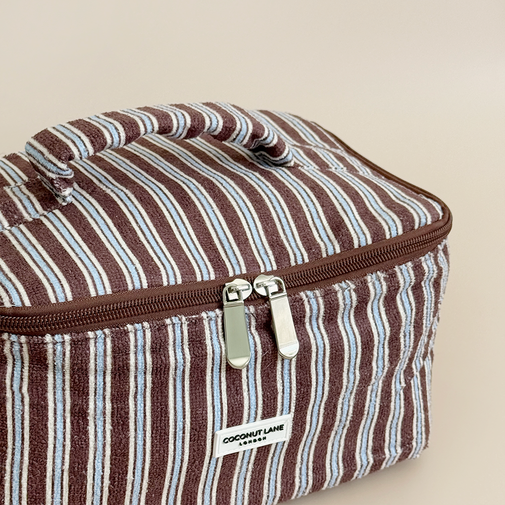 Brown, white and blue striped Vanity Case with silver zip and padded handle.