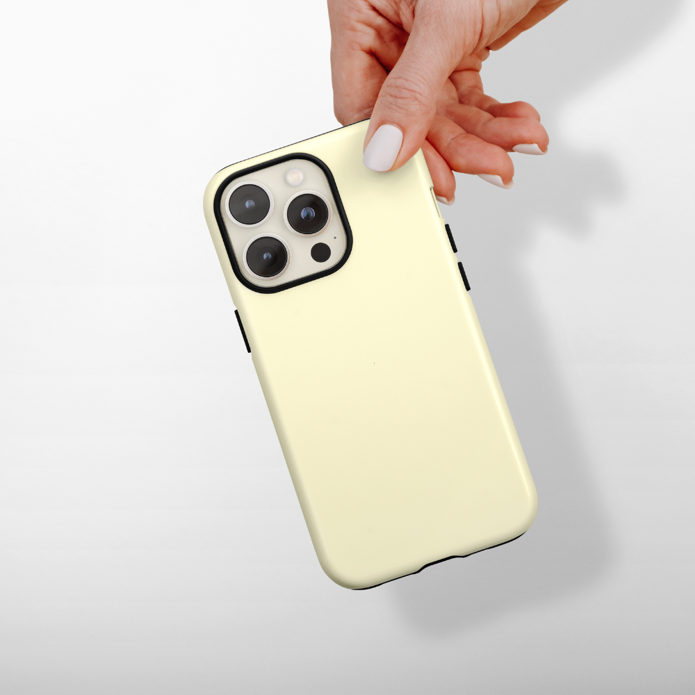 Hand holding a smartphone in a yellow Coconut Lane Tough Phone Case against a white background.