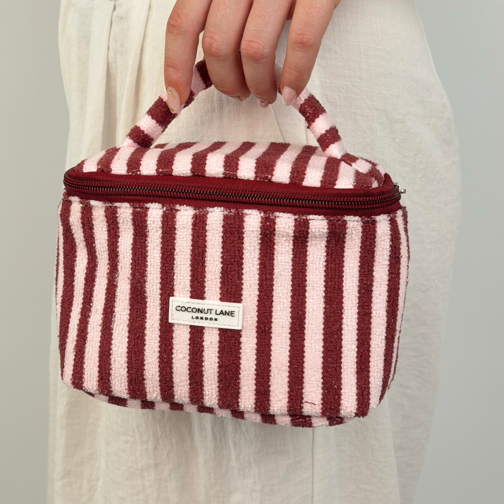 Girl holding mini vanity in blushberry stripes by handle