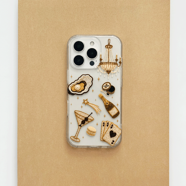 A clear phone case decorated with macron-style graphics of oysters, a cocktail, a champagne bottle, playing cards, and a macaron.