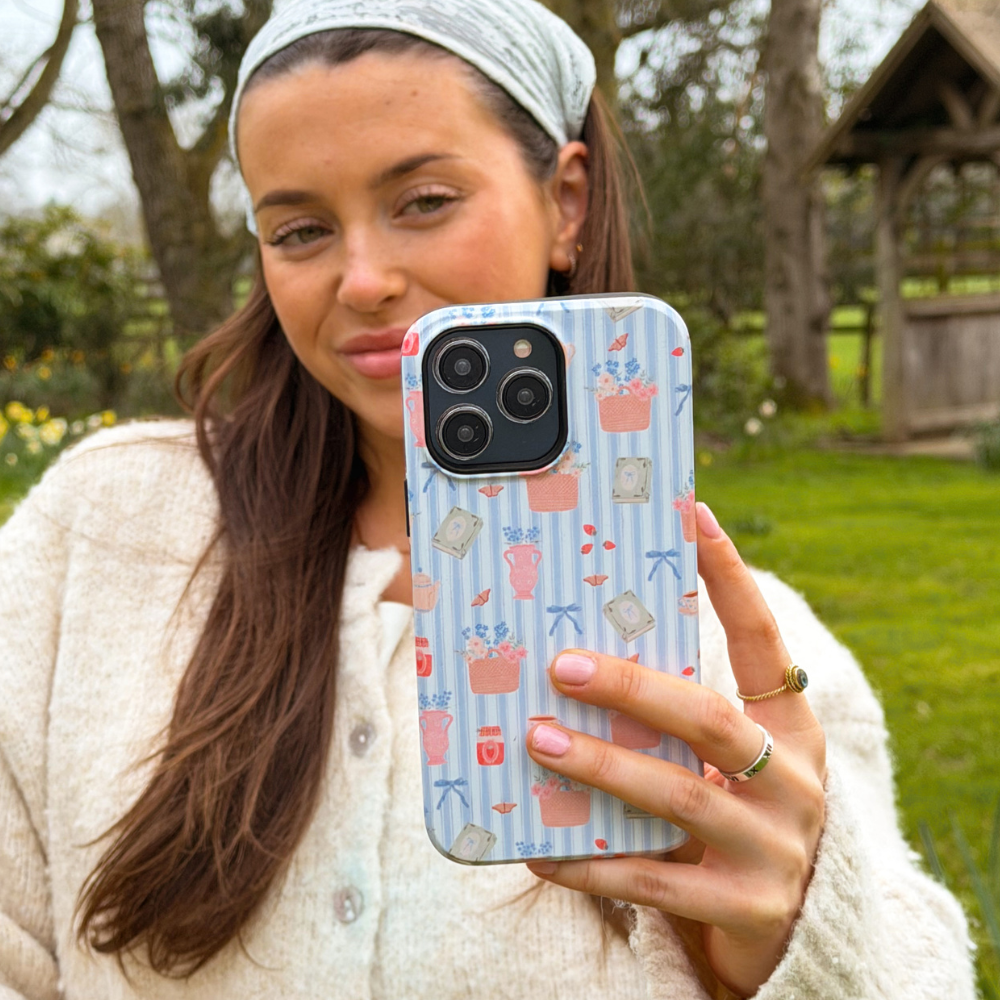 Girl taking selfie with tough cottage core phone case in a field