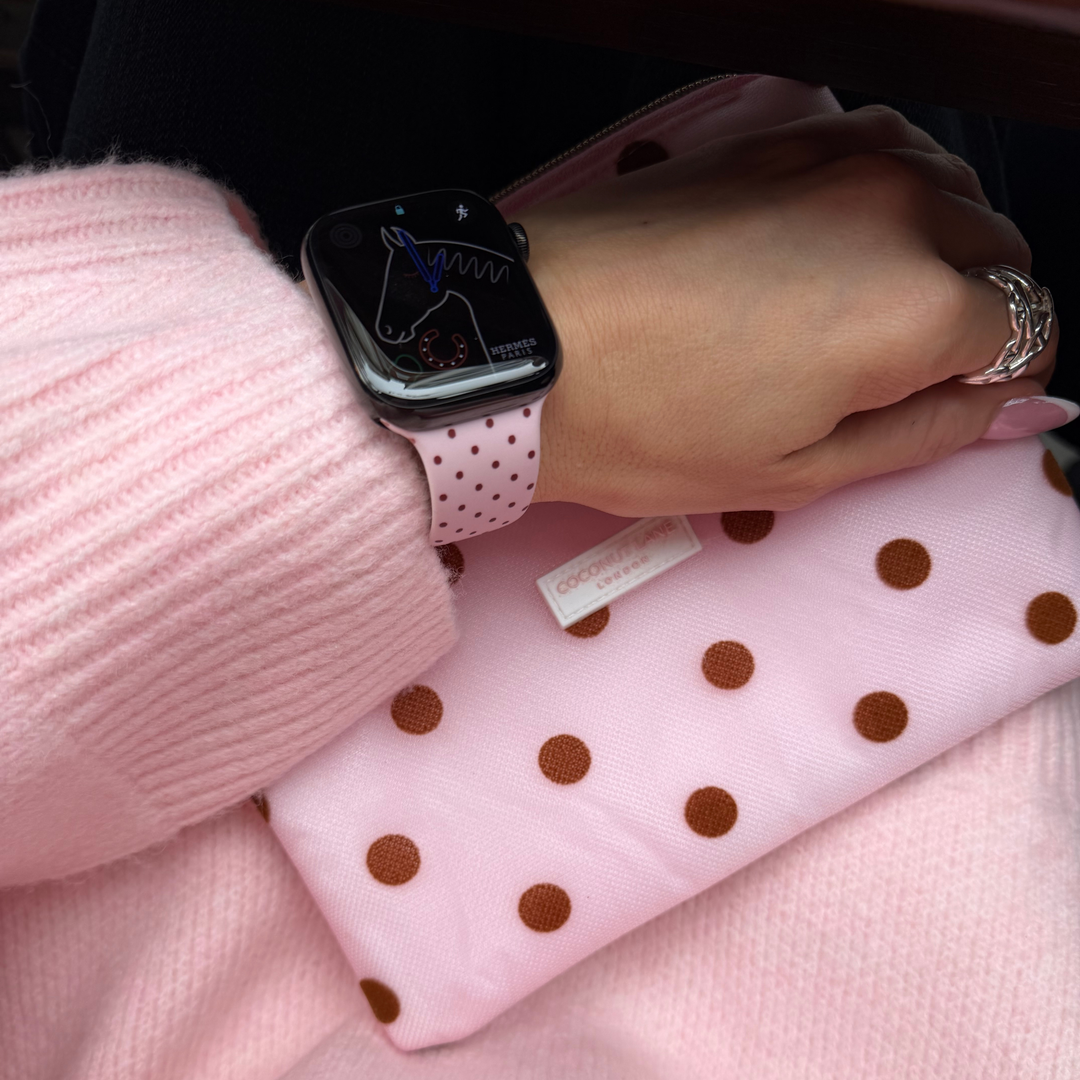 Dot Society Pink and Brown Everything Pouch. The pouch is sheer mesh material with brown polka dot detailing. Featuring in the photo is the matching Apple Watch Strap, pink with brown polka dots.
