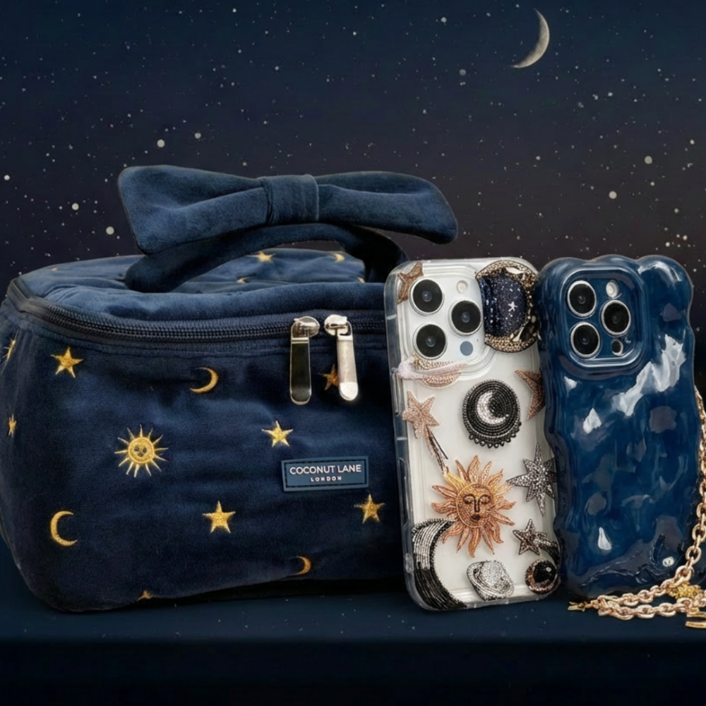 Navy velvet bag with gold star and sun designs, two phone cases, and a celestial-themed phone strap on dark fabric.