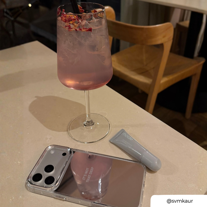 Mirror phone case placed on the table, with the text "It's not that deep" printed on the back in small font. 