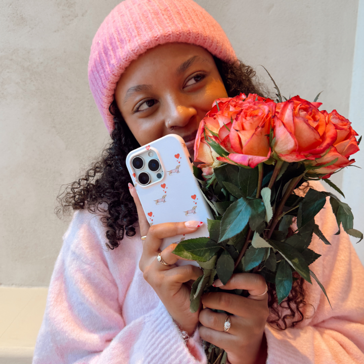 Girl smelling flowers holding Love Paws Phone Case