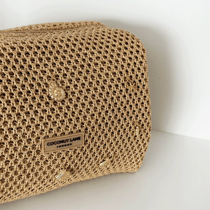 Beige woven bag with gold embellishments.