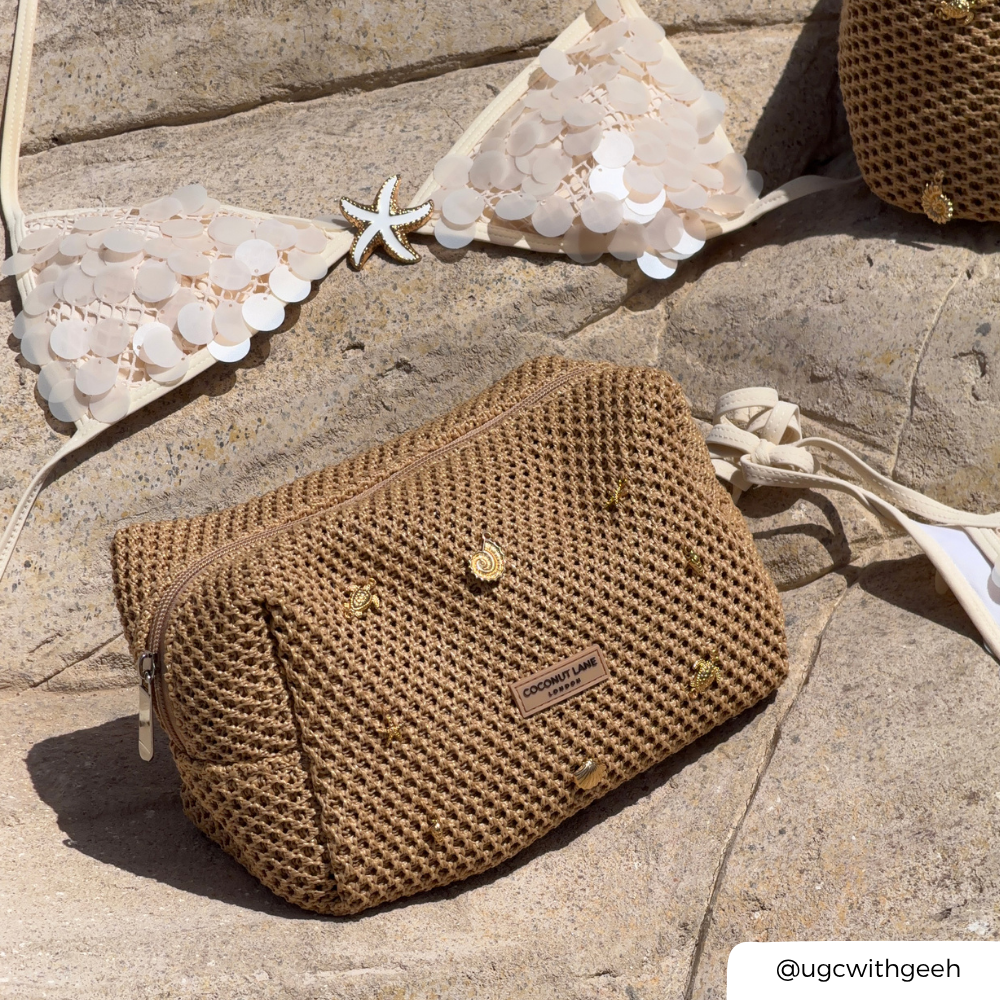 Brown woven makeup on a stone surface with a starfish and lace fabric in the background.