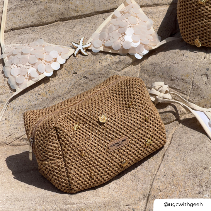 Brown woven makeup on a stone surface with a starfish and lace fabric in the background.