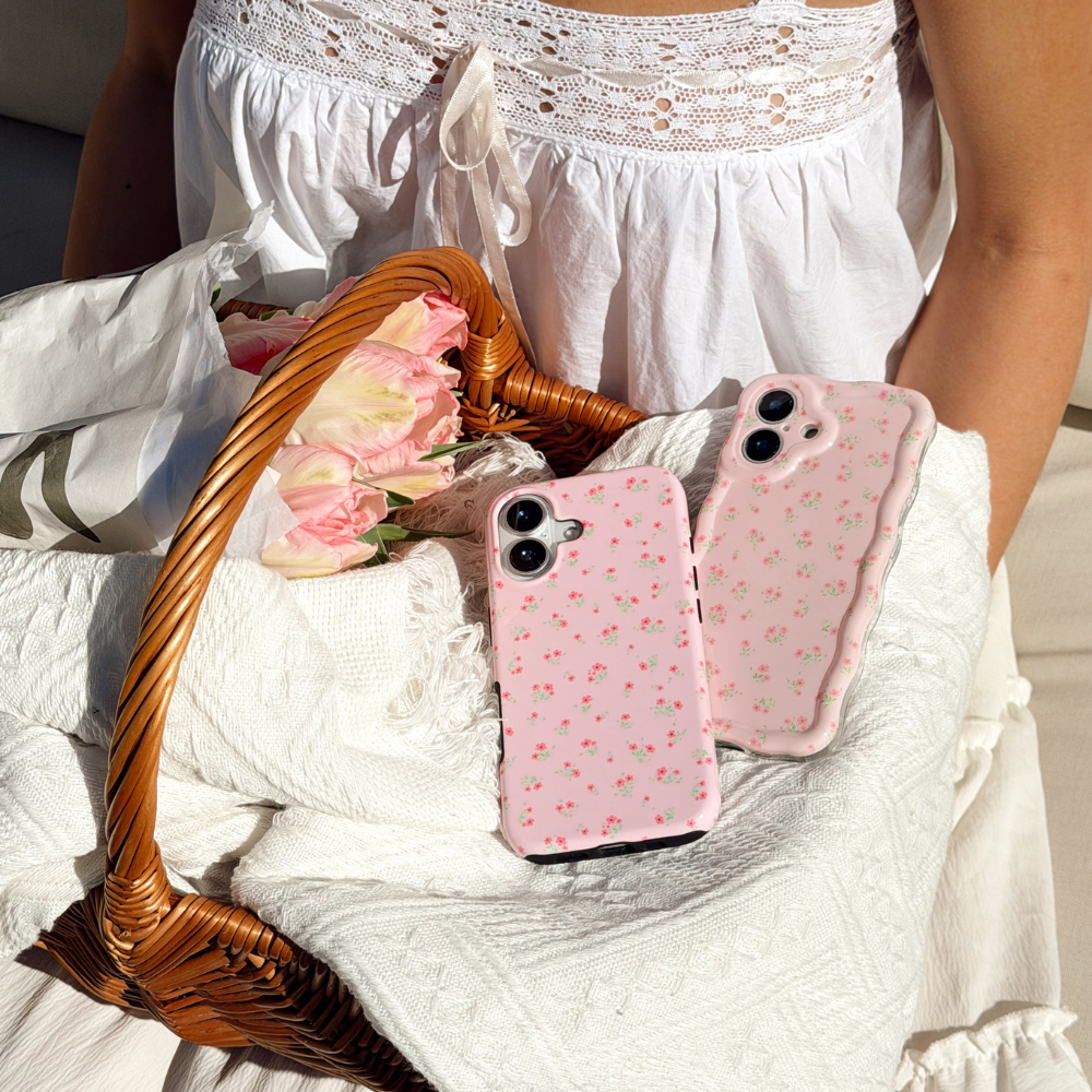 Tough Ditsy Floral pink in a basket next to flowers and the wavy ditsy floral pink phone case