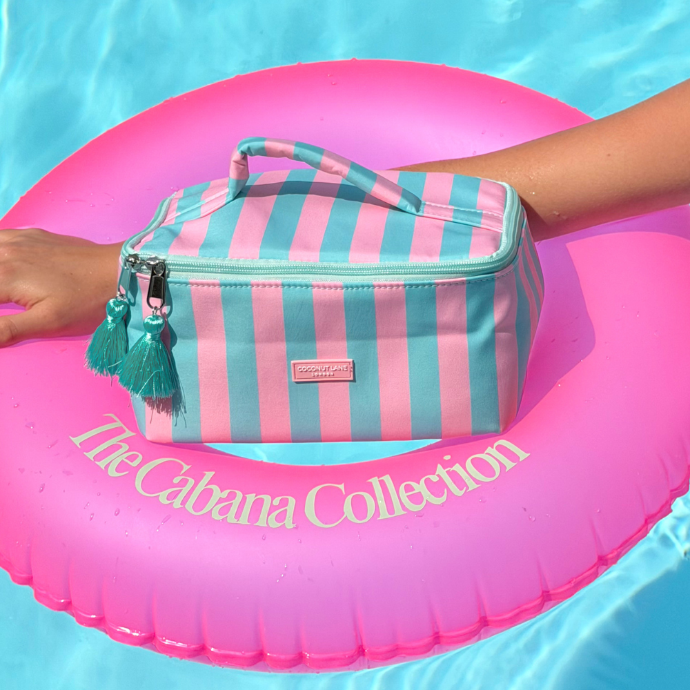 Striped Vanity Case on a pink inflatable ring with 'The Cabana Collection' text in clear water.