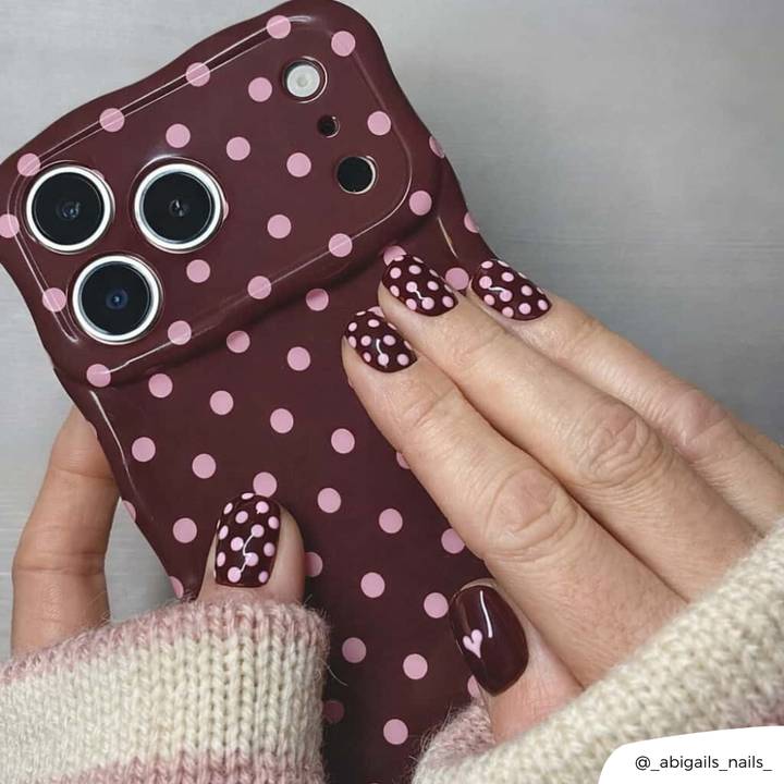 Girl matching her nails to the brown polka dot wavy phone case