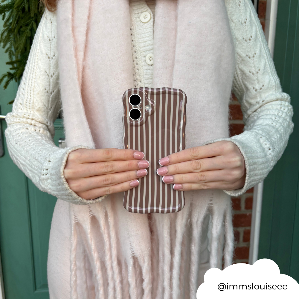 Hand holding Coconut Lane wavy phone case with chestnut brown and white stripes.
