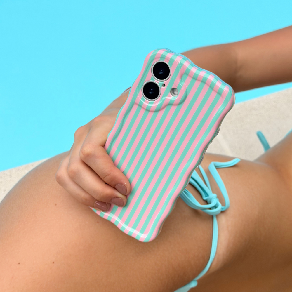 Wavy Phone case with pink and green stripes held by a person against a blue background