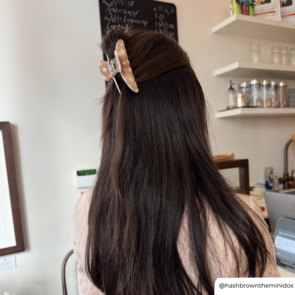 girl with long dark hair in a cafe wearing a fawn print claw clip