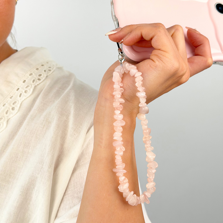 Girl with her rose quartz phone strap in a studio shoot